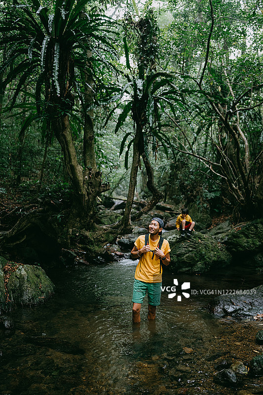 徒步穿越日本奄美大岛丛林河流的男人图片素材