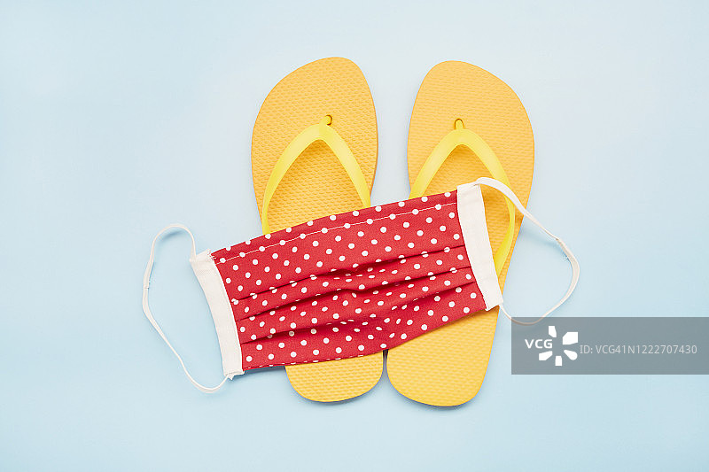 蓝色背景上的红色口罩和人字拖静物，DIY缝纫项目图片素材