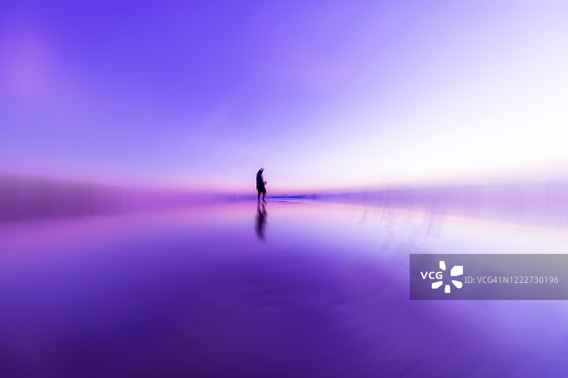 日出时拍摄的中心有人物形状的紫色漩涡图案图片素材