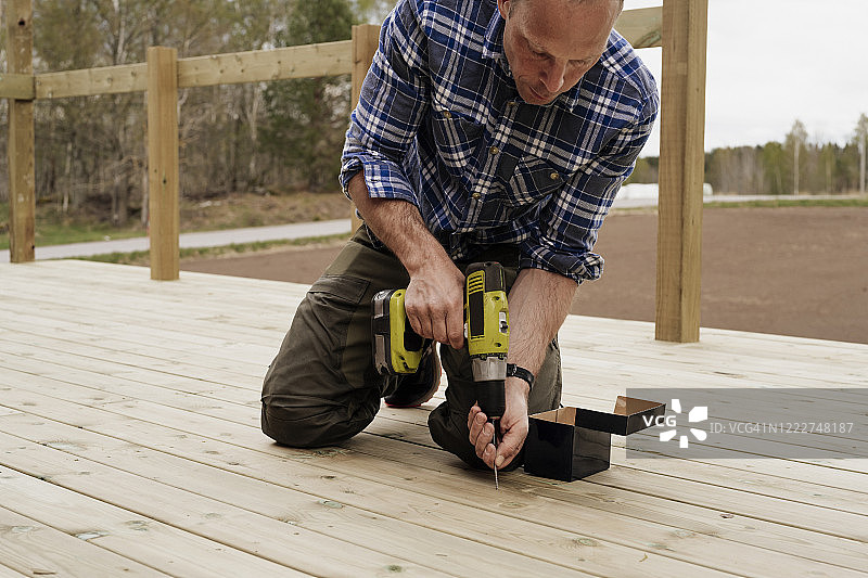 男人在花园里建造木制露台图片素材