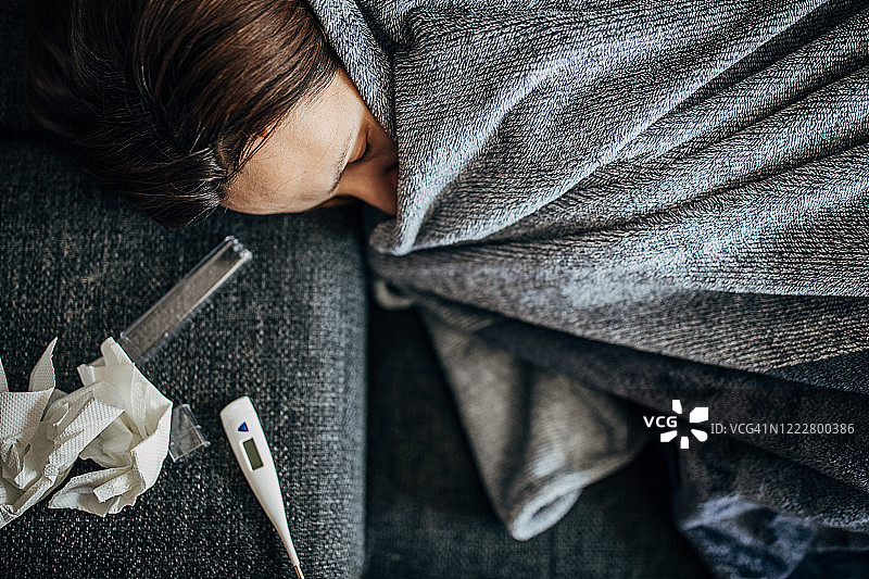有发烧症状躺在沙发上的女人图片素材