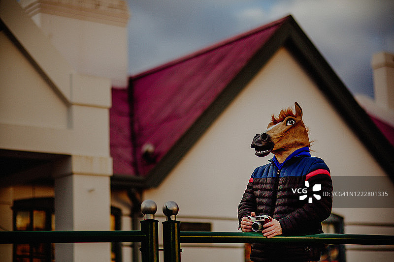戴着马头面具的男人，拿着相机图片素材