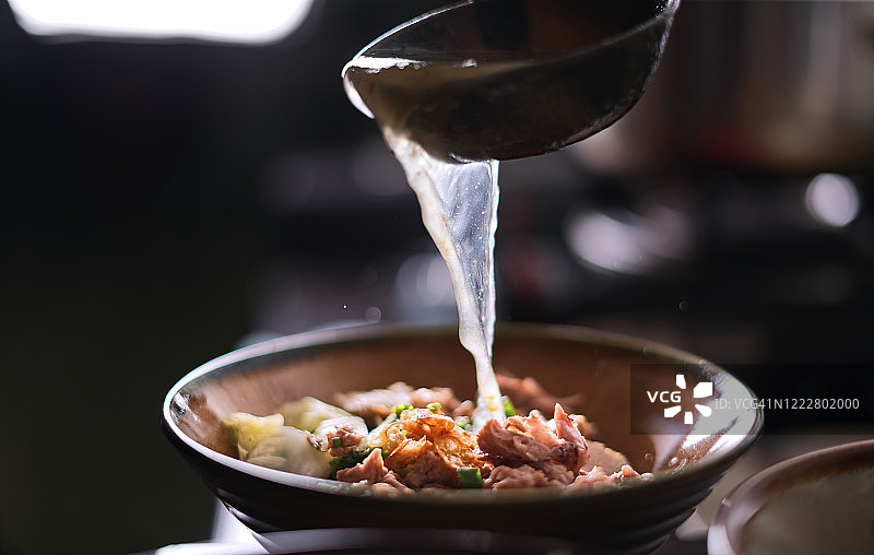 厨师往面碗里倒汤图片素材