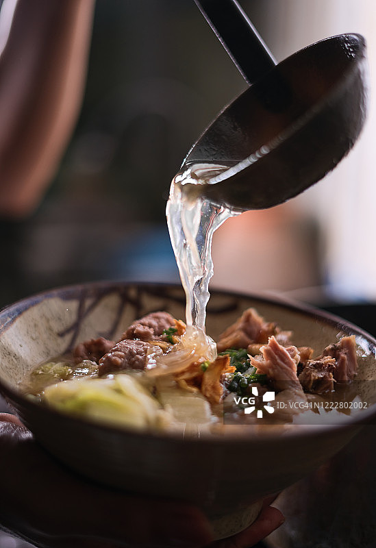 厨师往面碗里倒汤图片素材