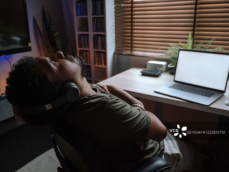 年轻男子在家用笔记本电脑玩电脑游戏图片素材