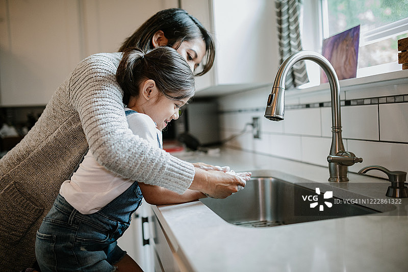 妈妈教女儿用正确方法洗手图片素材