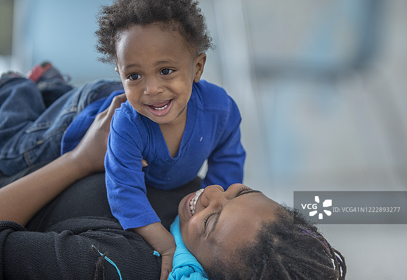 母亲和蹒跚学步的儿子一起玩耍图片素材
