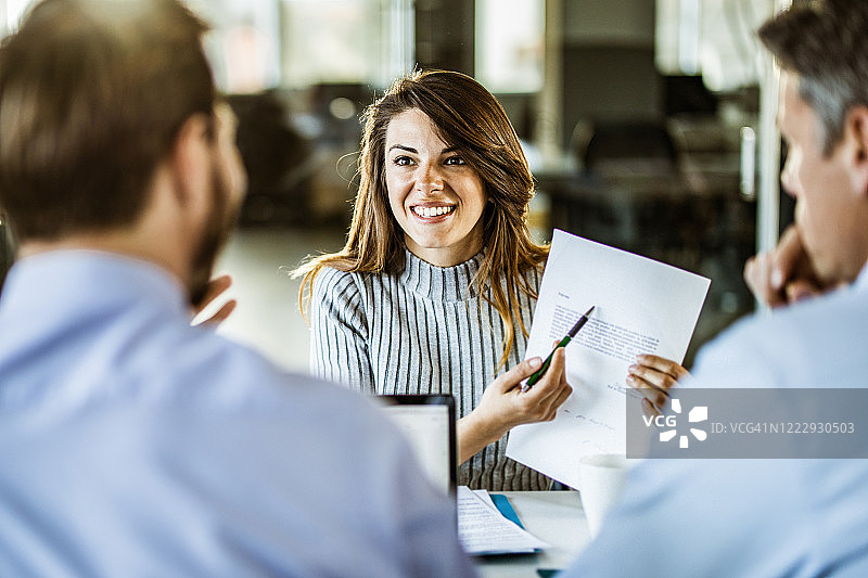 快乐的女性求职者在面试中谈论她的简历图片素材