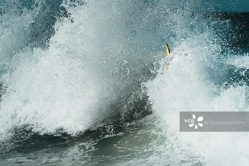 巨浪拍打着冲浪板一角图片素材