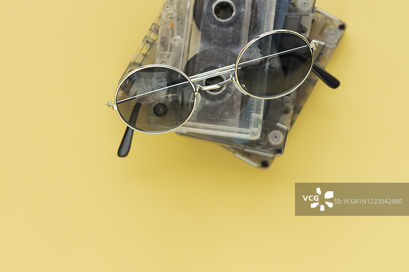 黄色背景上的磁带与复古太阳镜图片素材