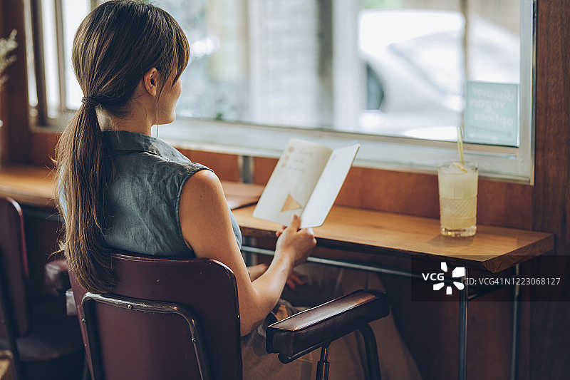 坐在咖啡馆里看笔记本的学生图片素材