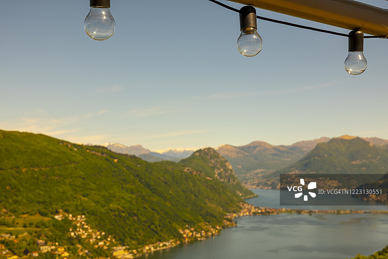 阳光明媚的卢加诺高山湖泊和山脉风光图片素材