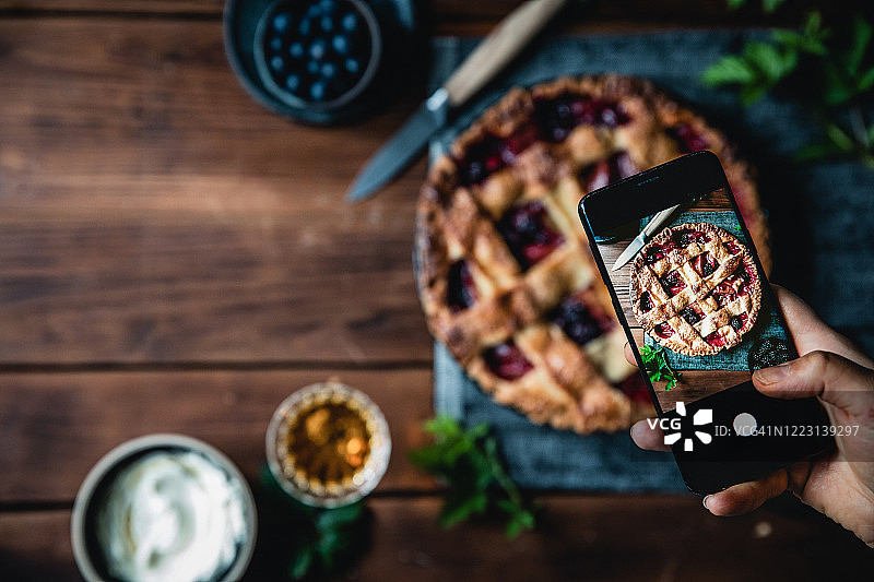年轻女子拍摄新鲜水果馅饼照片图片素材