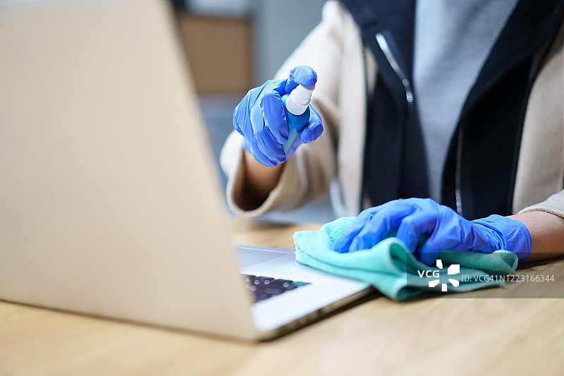 在办公室用消毒湿巾清洁笔记本电脑图片素材