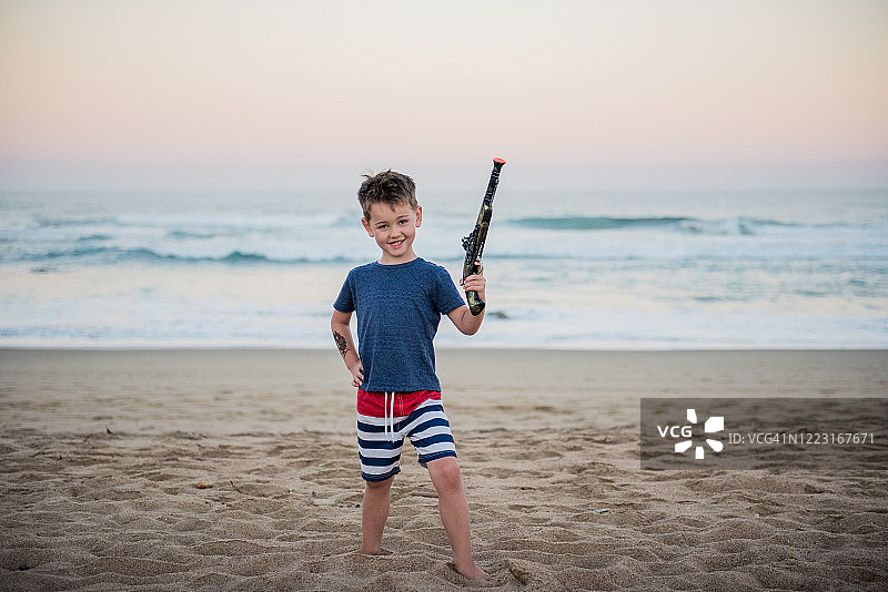 假日里，小男孩拿着玩具枪摆姿势图片素材