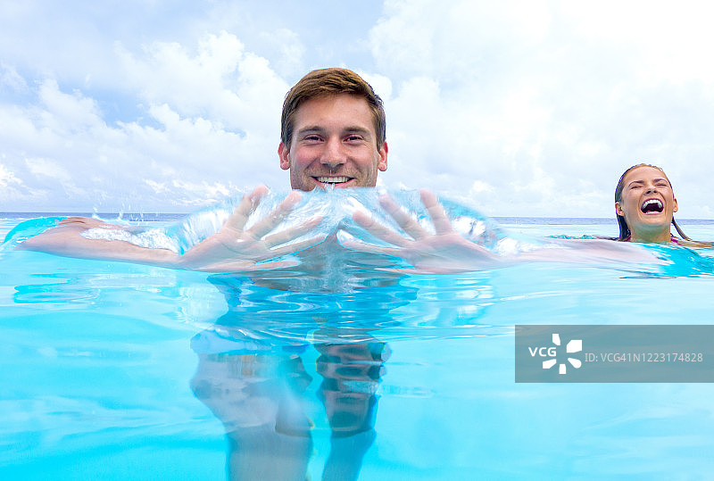 情侣在游泳池里玩耍图片素材