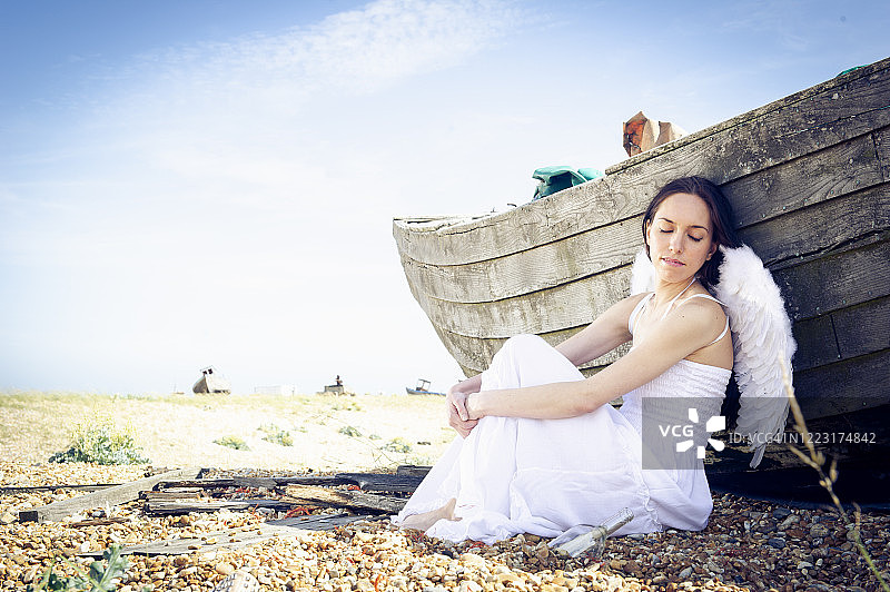 在海滩上戴着天使翅膀的女人图片素材