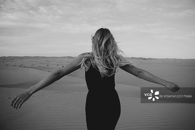 金发女子在美国Algodones Dunes沙漠的背影图片素材