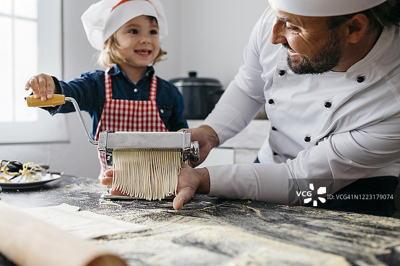 父女在家用面条机制作自制意大利面图片素材