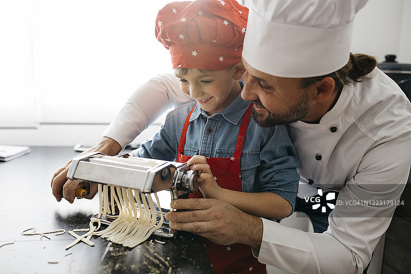 父子在家用面条机自制意大利面图片素材