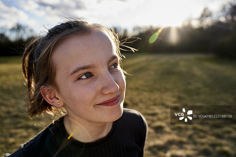 草地上微笑的女孩肖像图片素材