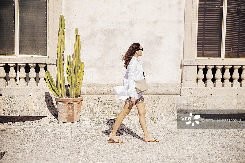 女人沿着美国佛罗里达州的老建筑行走图片素材