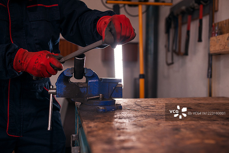在车间使用手动工具的金属工人图片素材