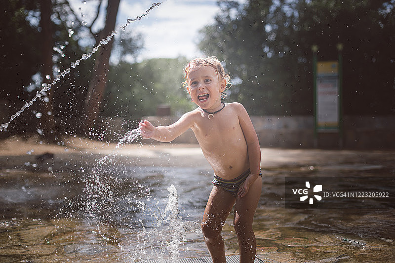男孩在公园里玩水图片素材