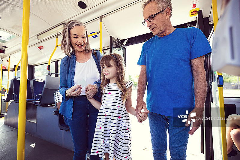 女孩和祖父母一起乘坐公交车图片素材