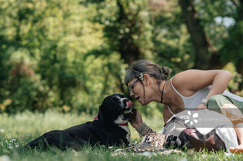 公园里抱着小狗的年轻女孩肖像图片素材