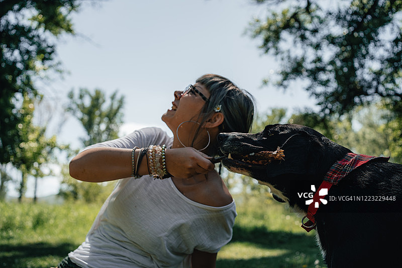 公园里抱着小狗的年轻女孩肖像图片素材
