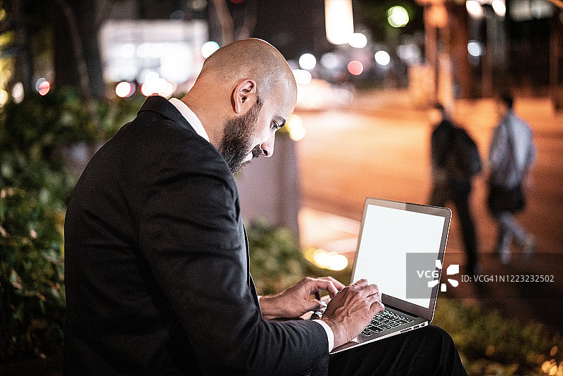 在户外使用笔记本电脑工作的商人图片素材