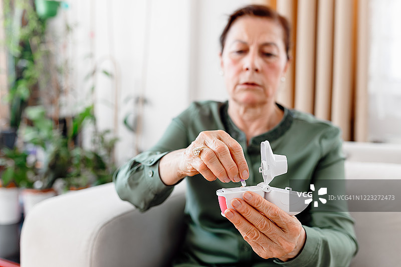 一位有哮喘病的老年妇女使用哮喘吸入器图片素材