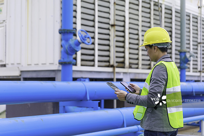 建筑工地戴安全帽，使用平板电脑的工程师图片素材