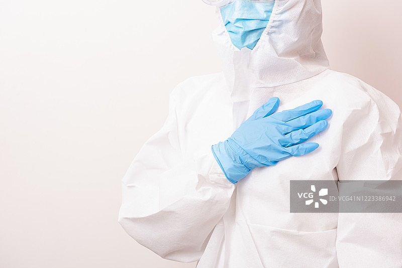 穿着全套防护服，手放在胸前的女医生图片素材