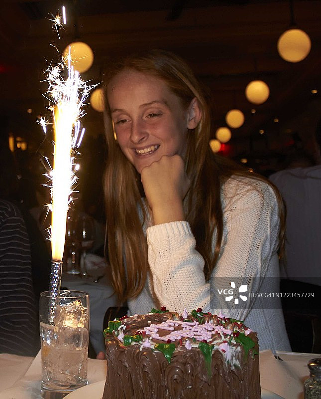 少女在餐厅庆祝生日，享用巧克力蛋糕图片素材