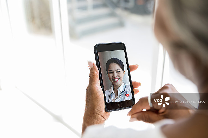 看不清脸的女人与医生进行视频聊天图片素材