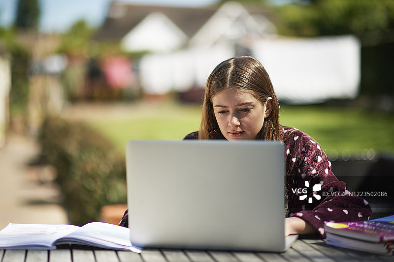 在花园里做功课的少女图片素材