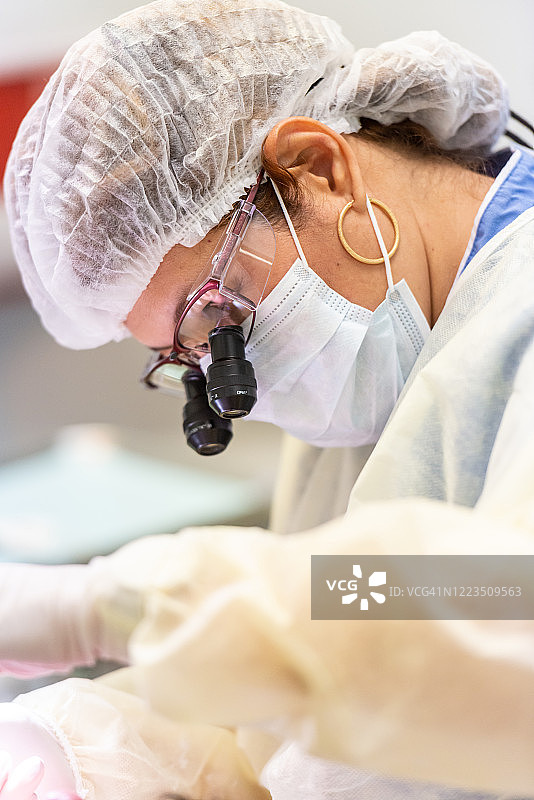 正在进行牙科手术的中年女牙医图片素材