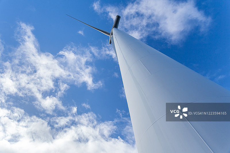 阴天旋转的风力涡轮机仰视视角图片素材