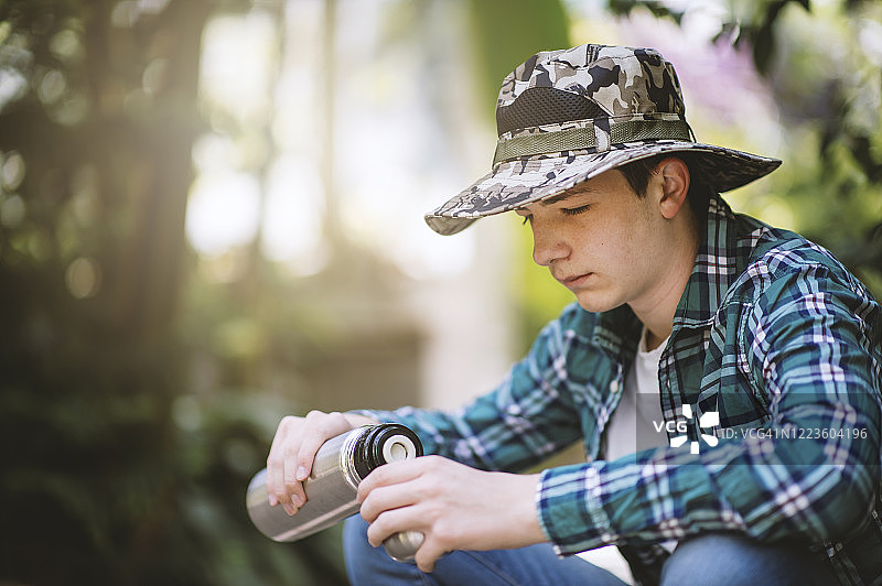 青少年在树林里休息，喝瓶装水图片素材