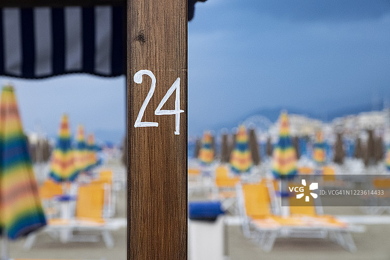 24号：空旷的沙滩、黄色躺椅和条纹伞图片素材