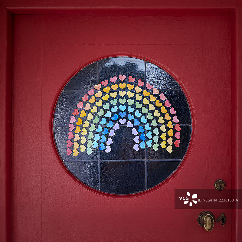 红门圆形窗户上组成彩虹的彩色心形纸片图片素材