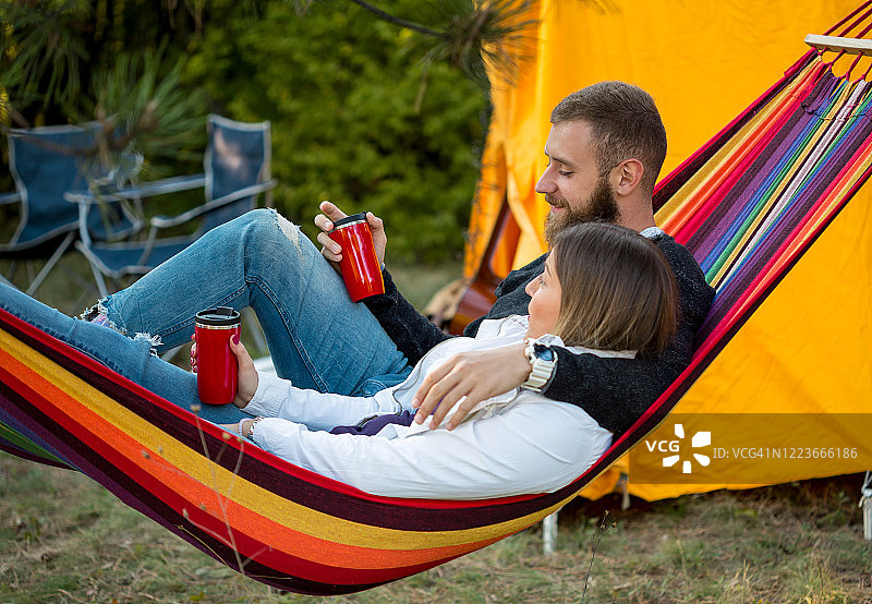 年轻男女在美丽的森林里吊床上图片素材