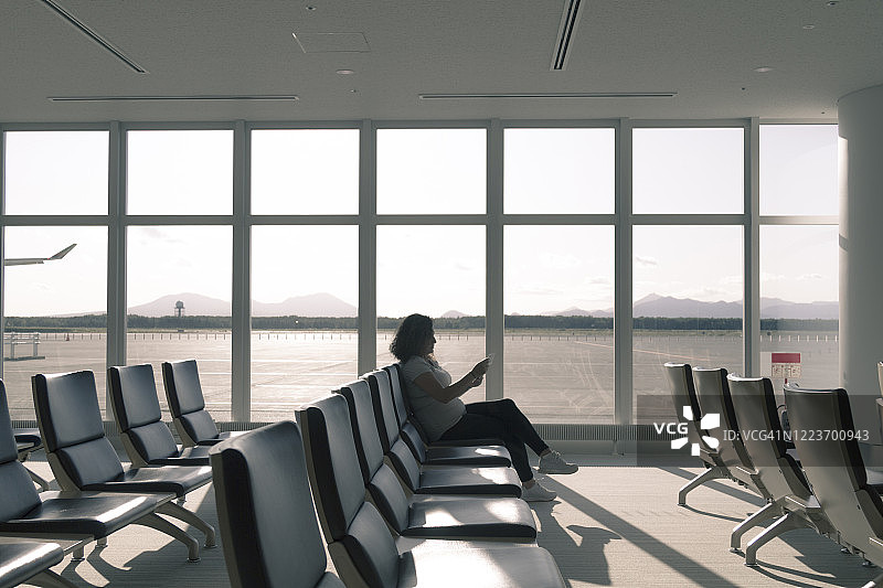 独自在机场候车室等待的年轻女游客图片素材