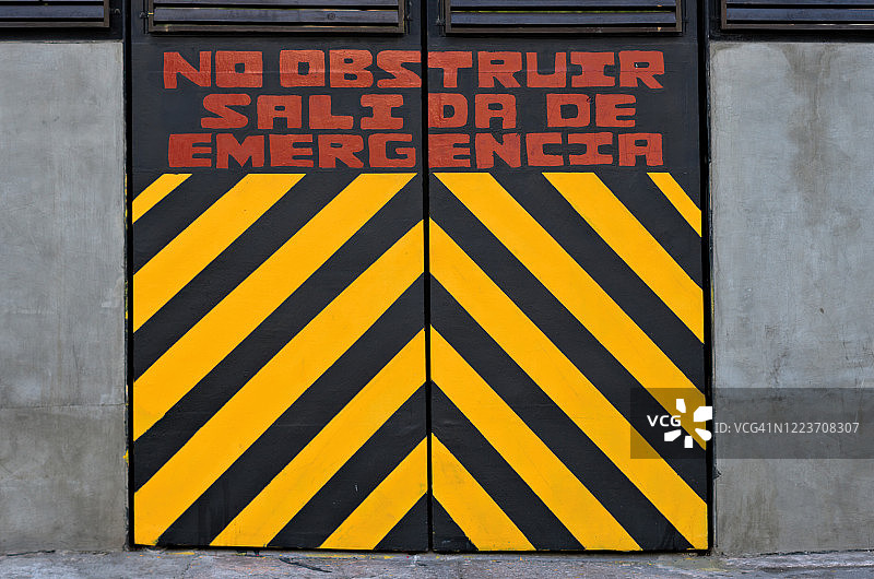 带有西班牙语警告标志的紧急出口门：“请勿阻塞，紧急出口”图片素材