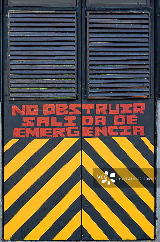 带有西班牙语警告标志的紧急出口门：“请勿阻塞，紧急出口”图片素材