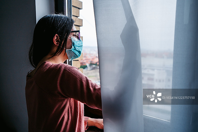 隔离中望着窗外的女人图片素材