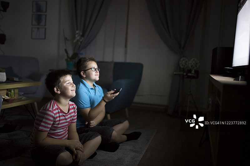 男孩们晚上在家看电影图片素材