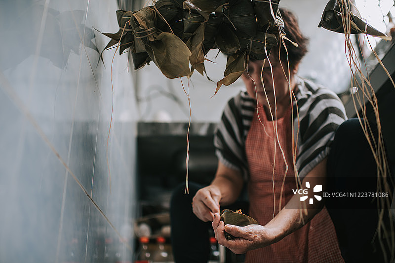 中国老年妇女在厨房准备粽子，为端午节做准备图片素材